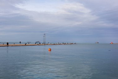 İtalya 'nın güzel bir sonbahar gününde, Trieste' nin Molo Audace rıhtımındaki insanlar