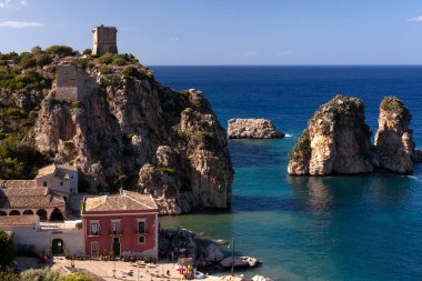 View of the Faraglioni and the tower Doria above the Tonnara Di Scopello. Beautiful seascape of village Scopello in Sicily, province of Trapani, Italy clipart