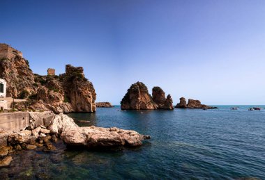 View of the famous Faraglioni , stacks of Scopello, immediately in front of the buildings of the former old tuna fishery called Tonnara