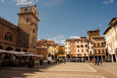 Mantova, İtalya - 15 Eylül 2024: Tarihi sarayları ve kilisesi olan Piazza delle Erbe 'deki saat kulesi
