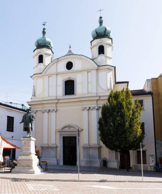 View of the Church of Santa Caterina, also known as the Sanctuary of Rosa Mistica, with the bronze monument to Maximilian I, Holy Roman Emperor, in Cormons, Italy clipart