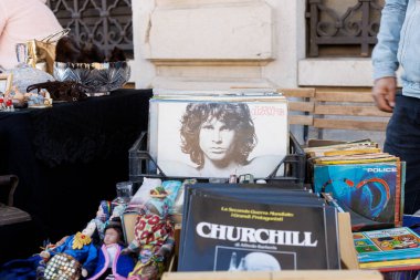 Trieste, İtalya - 29 Eylül 2024: Jim Morrison 'ın görüntüsü ve Churchill hakkında bir kitabın yer aldığı, bir sokak pazarında kitap ve vinil plaklarla dolu kutular.