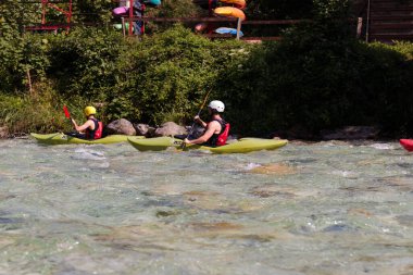Bovec, Slovenya - 18 Temmuz 2025: Bir öğrenme kursu veya eğitim oturumu sırasında ünlü turkuaz Soca Nehri 'nde bir grup kanocu