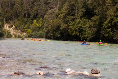 Bovec, Slovenya - 18 Temmuz 2025: Bir öğrenme kursu veya eğitim oturumu sırasında ünlü turkuaz Soca Nehri 'nde bir grup kanocu