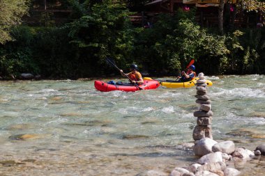 Bovec, Slovenya - 18 Temmuz 2025: Yaz mevsiminde güzel turkuaz Soca nehrinde sporcu kanoları