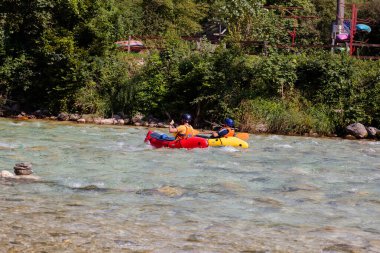 Bovec, Slovenya - 18 Temmuz 2025: Yaz mevsiminde güzel turkuaz Soca nehrinde sporcu kanoları