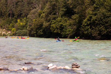 Bovec, Slovenya - 18 Temmuz 2025: Bir öğrenme kursu veya eğitim oturumu sırasında ünlü turkuaz Soca Nehri 'nde bir grup kanocu