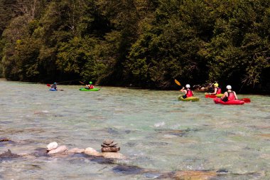 Bovec, Slovenya - 18 Temmuz 2025: Bir öğrenme kursu veya eğitim oturumu sırasında ünlü turkuaz Soca Nehri 'nde bir grup kanocu