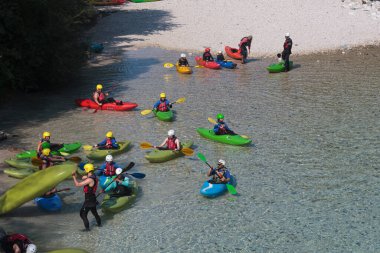 Bovec, Slovenya - 18 Temmuz 2025: Bir öğrenme kursu veya eğitim oturumu sırasında ünlü turkuaz Soca Nehri 'nde bir grup kanocu