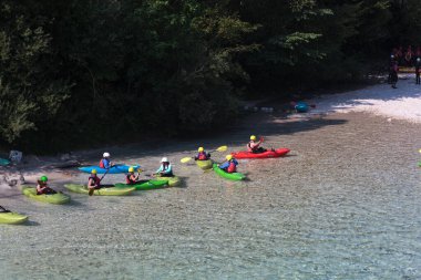 Bovec, Slovenya - 18 Temmuz 2025: Bir öğrenme kursu veya eğitim oturumu sırasında ünlü turkuaz Soca Nehri 'nde bir grup kanocu