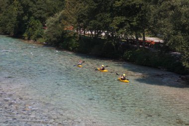 Bovec, Slovenya - 18 Temmuz 2025: Yaz mevsiminde güzel turkuaz Soca nehrinde sporcu kanoları