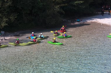 Bovec, Slovenya - 18 Temmuz 2025: Bir öğrenme kursu veya eğitim oturumu sırasında ünlü turkuaz Soca Nehri 'nde bir grup kanocu