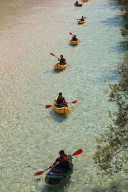 Bovec, Slovenya - 18 Temmuz 2025: Yaz mevsiminde güzel turkuaz Soca nehrinde sporcu kanoları