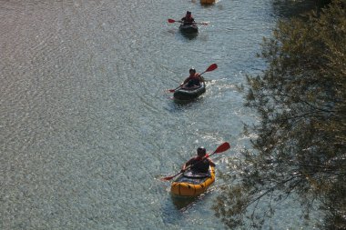 Bovec, Slovenya - 18 Temmuz 2025: Yaz mevsiminde güzel turkuaz Soca nehrinde sporcu kanoları