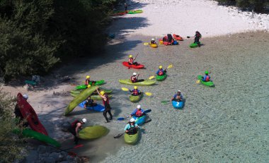 Bovec, Slovenya - 18 Temmuz 2025: Bir öğrenme kursu veya eğitim oturumu sırasında ünlü turkuaz Soca Nehri 'nde bir grup kanocu