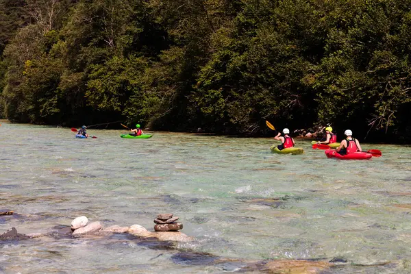 Bovec, Slovenya - 18 Temmuz 2025: Bir öğrenme kursu veya eğitim oturumu sırasında ünlü turkuaz Soca Nehri 'nde bir grup kanocu
