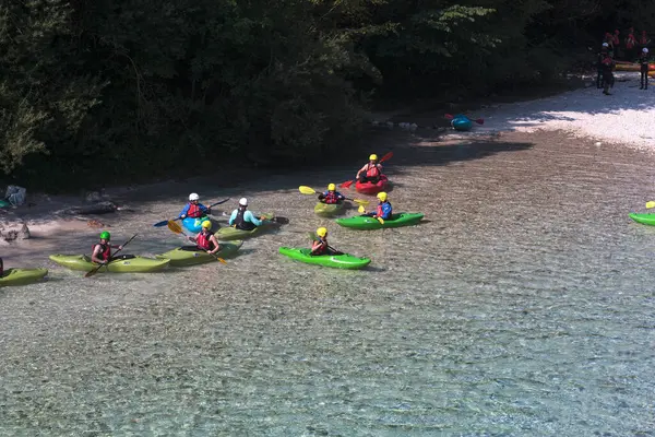 Bovec, Slovenya - 18 Temmuz 2025: Bir öğrenme kursu veya eğitim oturumu sırasında ünlü turkuaz Soca Nehri 'nde bir grup kanocu