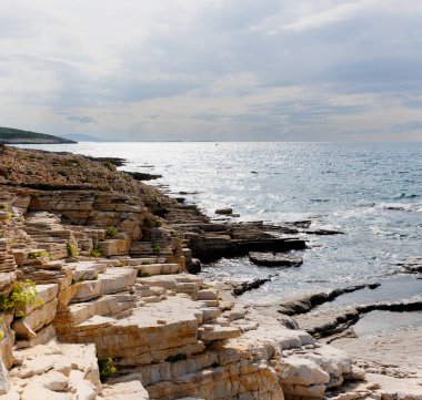 Hırvatistan 'ın Istria kentindeki Medulin belediyesindeki Premantura yarımadasındaki Kamenjak Ulusal Parkı' nın engebeli kireçtaşı manzarası yaz mevsiminde