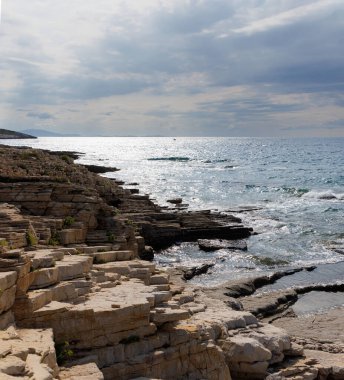 Hırvatistan 'ın Istria kentindeki Medulin belediyesindeki Premantura yarımadasındaki Kamenjak Ulusal Parkı' nın engebeli kireçtaşı manzarası yaz mevsiminde