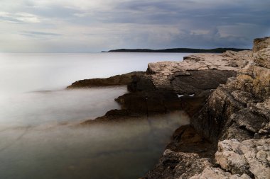 Hırvatistan 'ın Istria kentindeki Medulin belediyesindeki Premantura yarımadasındaki Kamenjak Ulusal Parkı' nın engebeli kireçtaşı manzarası yaz mevsiminde