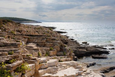 Hırvatistan 'ın Istria kentindeki Medulin belediyesindeki Premantura yarımadasındaki Kamenjak Ulusal Parkı' nın engebeli kireçtaşı manzarası yaz mevsiminde