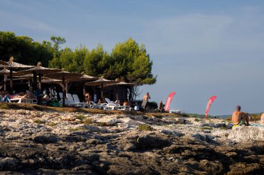 Premantura, Hırvatistan - 22 Ağustos 2024: Kamenjak Milli Parkı üzerinde açık mavi gökyüzü olan sahil barı