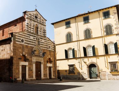 Lucca, İtalya 'daki Romanesk San Giusto Kilisesi cephesi, çizgili mermer bantlar, kör atari salonları, yuvarlak pencereler, yontulmuş portallar ve çan gable.