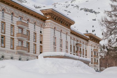 Maloja, İsviçre - Mart 2024: Karlı dağlarla çevrili zarif Maloja Palace Hotel 'in mimarisi 