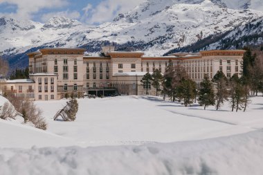 Maloja, İsviçre - Mart 2024: Karlı dağlarla çevrili zarif Maloja Palace Hotel 'in mimarisi 