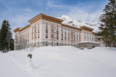 Maloja, İsviçre - Mart 2024: Karlı dağlarla çevrili zarif Maloja Palace Hotel 'in mimarisi 