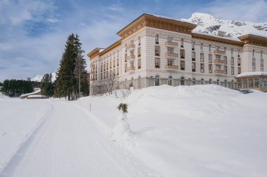 Maloja, İsviçre - Mart 2024: Karlı dağlarla çevrili zarif Maloja Palace Hotel 'in mimarisi 