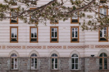 Maloja, İsviçre - Mart 2024: Karlı dağlarla çevrili zarif Maloja Palace Hotel 'in mimarisi 