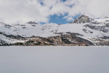 Saint Moritz, İsviçre - Mart 2024: Sils gölü ve Maloja köyü etrafında karla kaplı nefes kesici dağlar