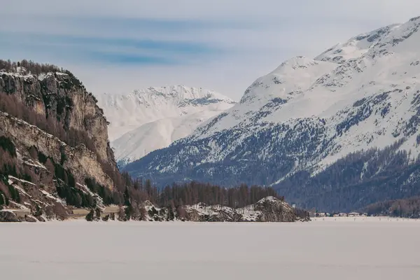 Saint Moritz, İsviçre - Mart 2024: Sils gölü ve Maloja köyü etrafında karla kaplı nefes kesici dağlar