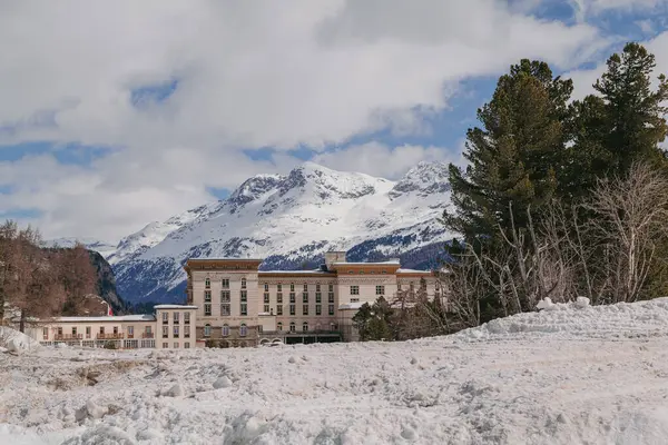 Maloja, İsviçre - Mart 2024: Karlı dağlarla çevrili zarif Maloja Palace Hotel 'in mimarisi 