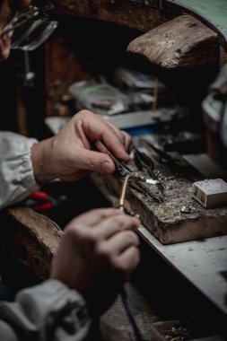 Usta bir kuyumcunun elleri altın ve değerli metaller üzerinde çalışır.