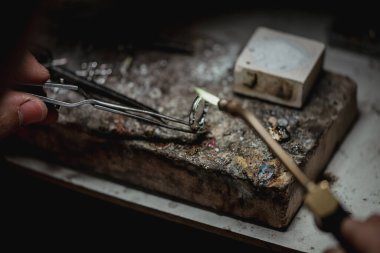 Usta bir kuyumcunun elleri altın ve değerli metaller üzerinde çalışır.