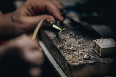 Usta bir kuyumcunun elleri altın ve değerli metaller üzerinde çalışır.