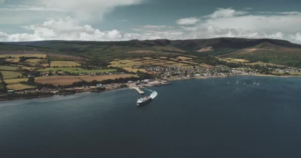汽船从苏格兰海岸出发 空中景观 苏格兰的风景 绿树成荫的山谷和群山 Arran岛Brodick终点站 — 图库视频影像