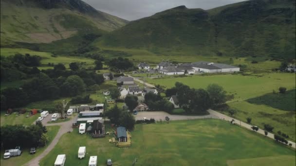 スコットランドのアーラン ウイスキー蒸留所は 緑豊かな渓谷の道路に沿って山々を蒸留します コテージ 村でキャンプ インドネシアのスコットランドの夏の風景 フッテージショット ストック動画