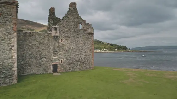 閉鎖スコットランドの城の壁空中撮影の風景 湾の前に夏の曇りの日に劇的な景色 英国アーラン島の海岸にハミルトン王朝の壮大な宮殿 映像表示 — ストック写真