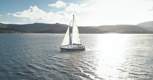 慢动作快艇在海洋湾与高浪岛海岸航空赛跑 阳光反射在帆船上 苏格兰阿尔兰岛海滨的阳光反射 夏季游轮豪华船 图库图片