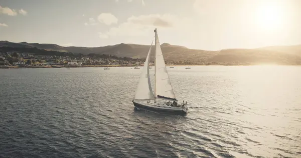 白い帆船の航空機が付いている太陽の海岸 夏に帆船で風景を凍らせている オーシャンベイの帆船の上の日光 船とアラン島の海岸 セレンウォーターシーナリードローンショット ロイヤリティフリーのストック写真