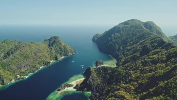 海岸の海岸を望む緑の山の島々 フィリピンのエルニドの丘の島々で熱帯林の海岸 夏の晴れた日の青い海水の自然景色 ストック動画