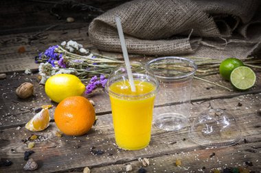 Plastik bir içecek bardağında plastik tüp ile portakal suyu.