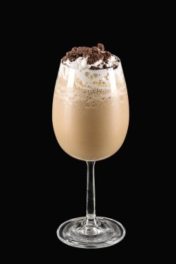 Kurabiyeler ve kremalı milkshake siyah arka planda bir bardakta