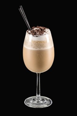 Kurabiyeler ve kremalı milkshake siyah arka planda bir bardakta