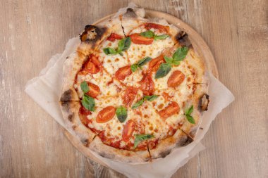 Tuğla fırınından ev yapımı Napoli usulü pizza margaritası. Napolyon İtalyan pizzası ve fesleğen yaprakları. Gerçek İtalyan Geleneksel Pizza Margherita