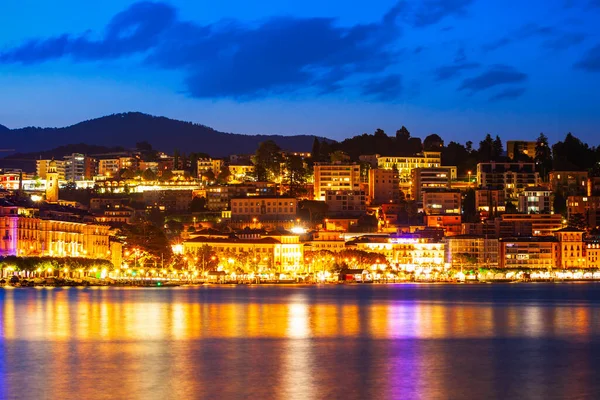 スイスのティチーノ州の夜にルガーノ湖とルガーノ市のパノラマビュー ストック画像