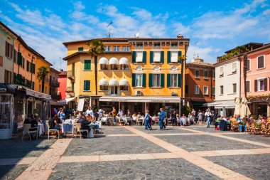 SIRMIONE, ITALY - APRIL 12, 2019: Street cafe in the centre of the Sirmione town, located at the Garda lake in Italy clipart